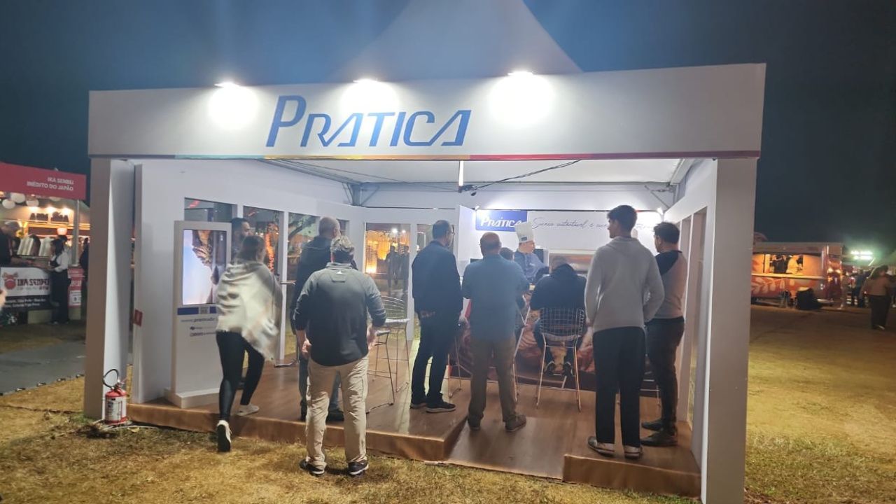 Um grupo de pessoas está em volta de uma cabine à noite.
