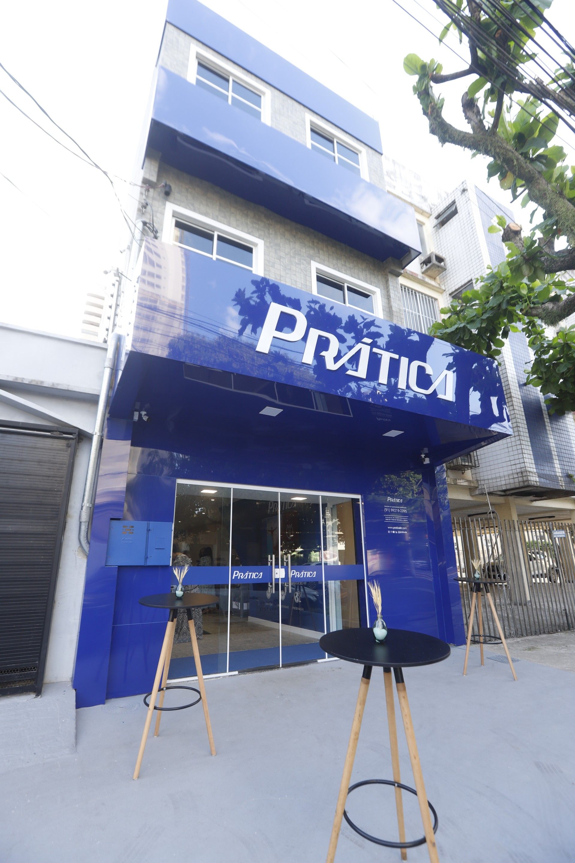 Prédio azul e cinza com placa 