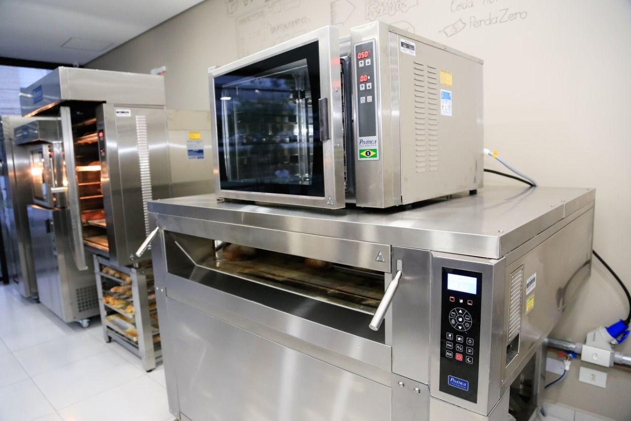 Um forno de aço inoxidável está em cima de outro forno em uma cozinha.