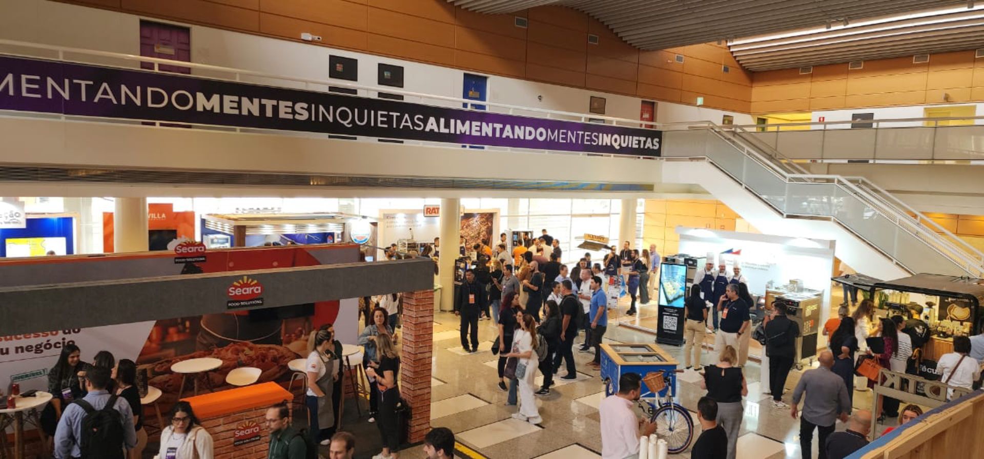 Um grande grupo de pessoas está em um shopping.