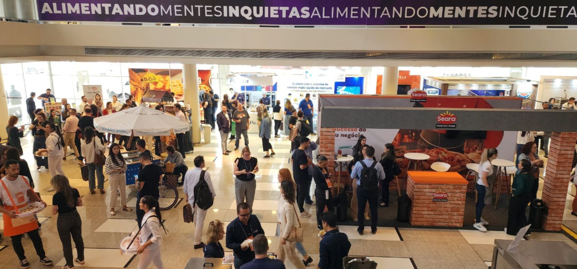 Um grande grupo de pessoas está reunido em um shopping