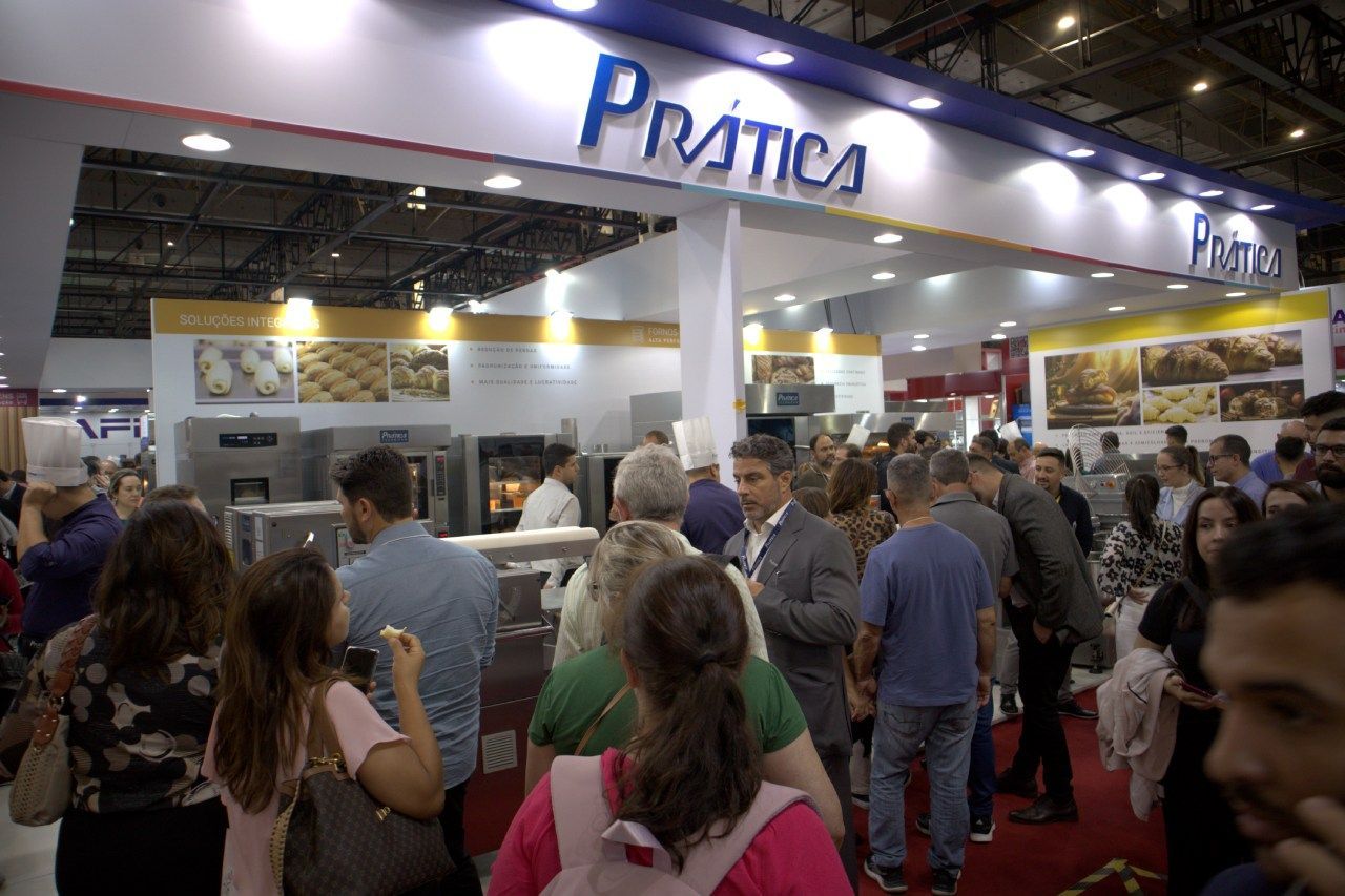 Um grupo de pessoas está em frente a uma loja chamada pratica.
