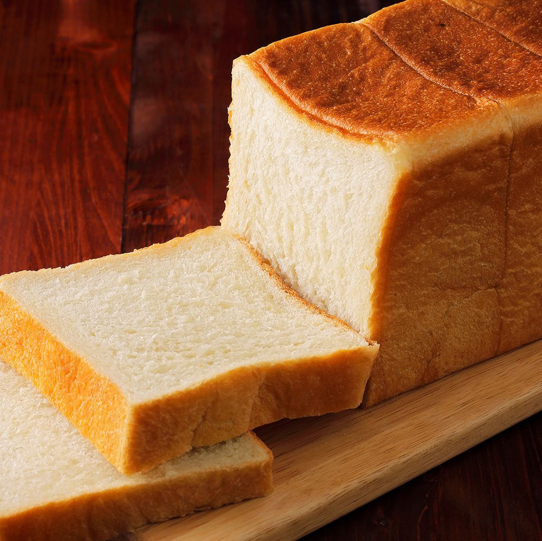 Um pedaço de pão está sobre uma tábua de corte de madeira