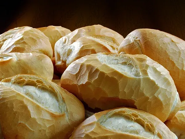 Um monte de pãezinhos estão empilhados uns sobre os outros sobre uma mesa.