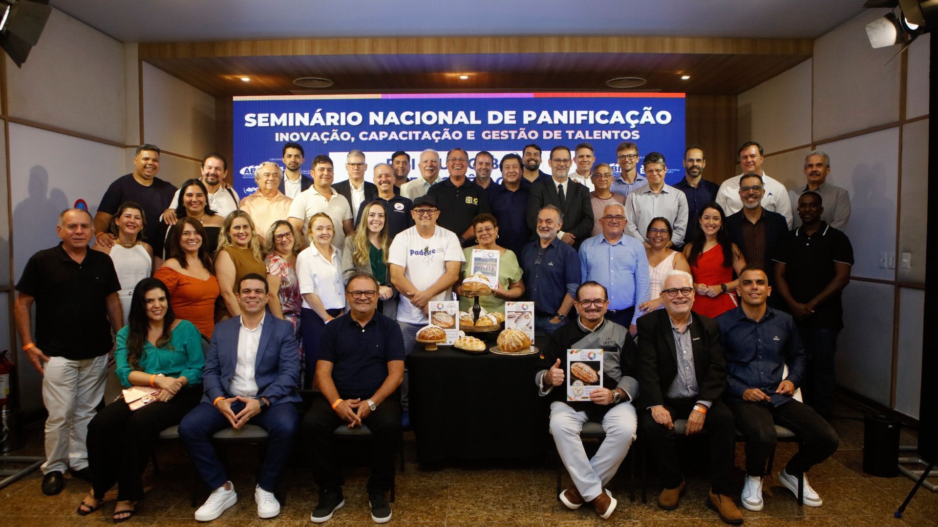 Um grupo de pessoas está posando para uma foto em uma sala.