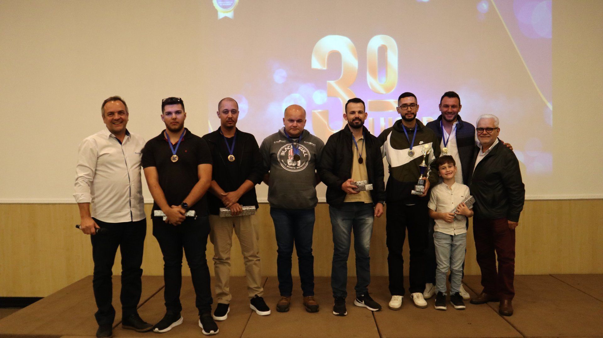 Um grupo de homens está posando para uma foto em um palco.