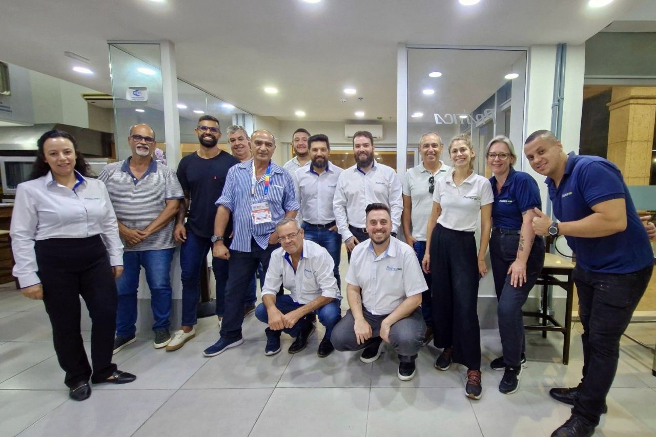 Um grupo de pessoas está posando para uma foto em uma sala.