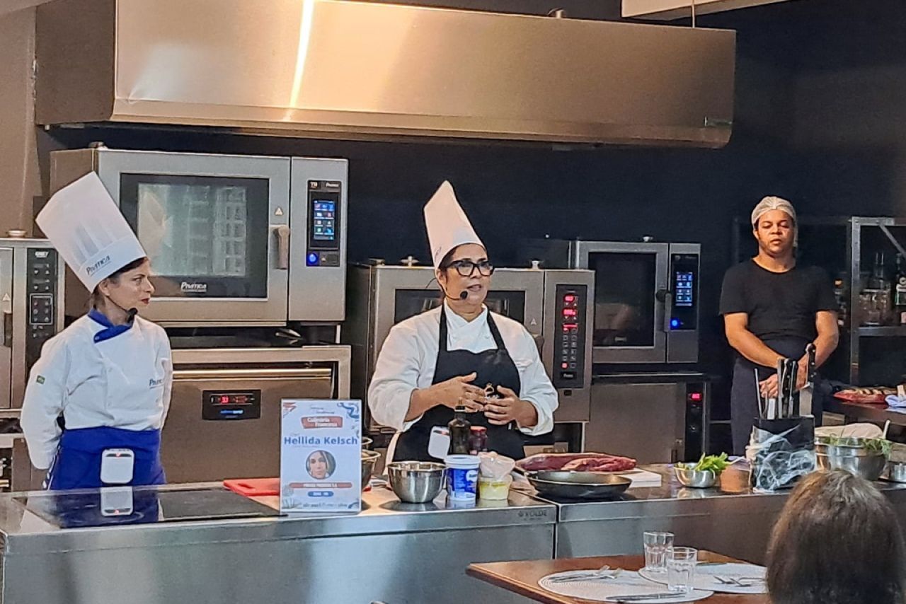 Um grupo de chefs está em uma cozinha fazendo uma apresentação.