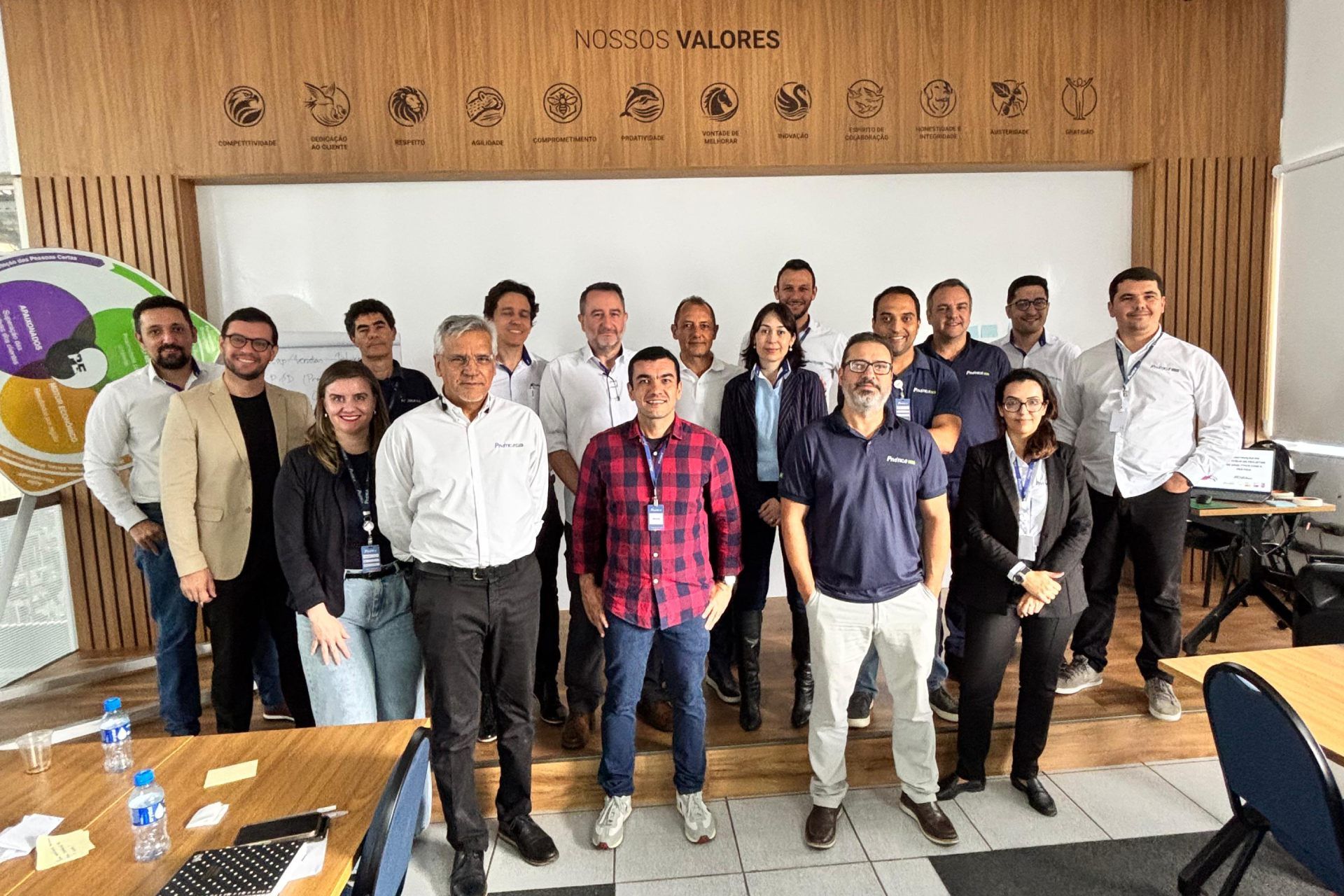 Um grupo de pessoas está posando para uma foto em uma sala.