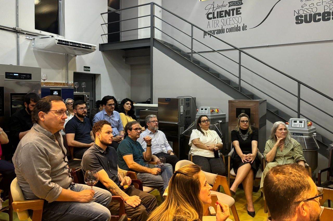 Um grupo de pessoas está sentado em círculo em uma sala.