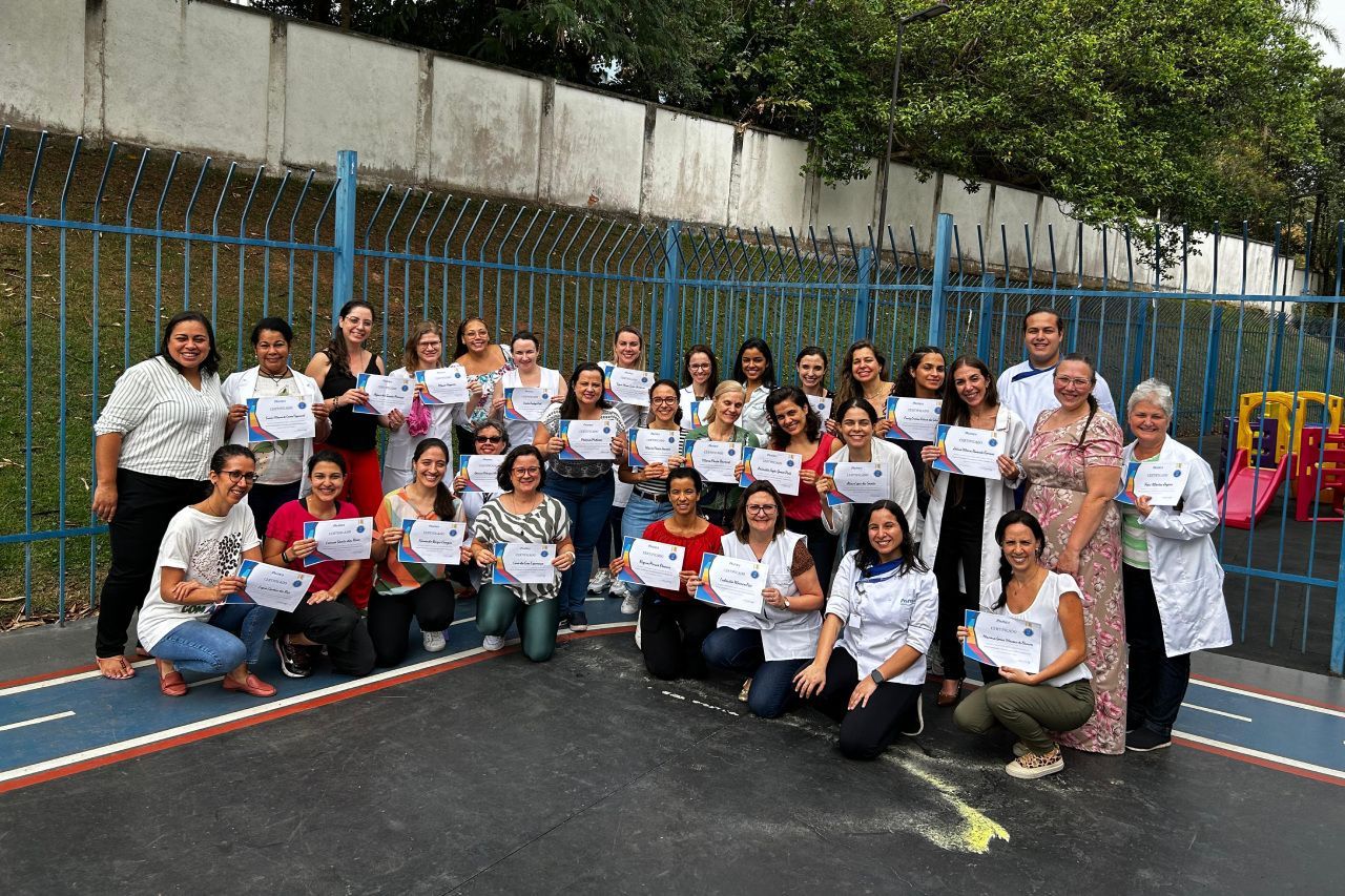 Um grupo de mulheres posando para uma foto segurando certificados.