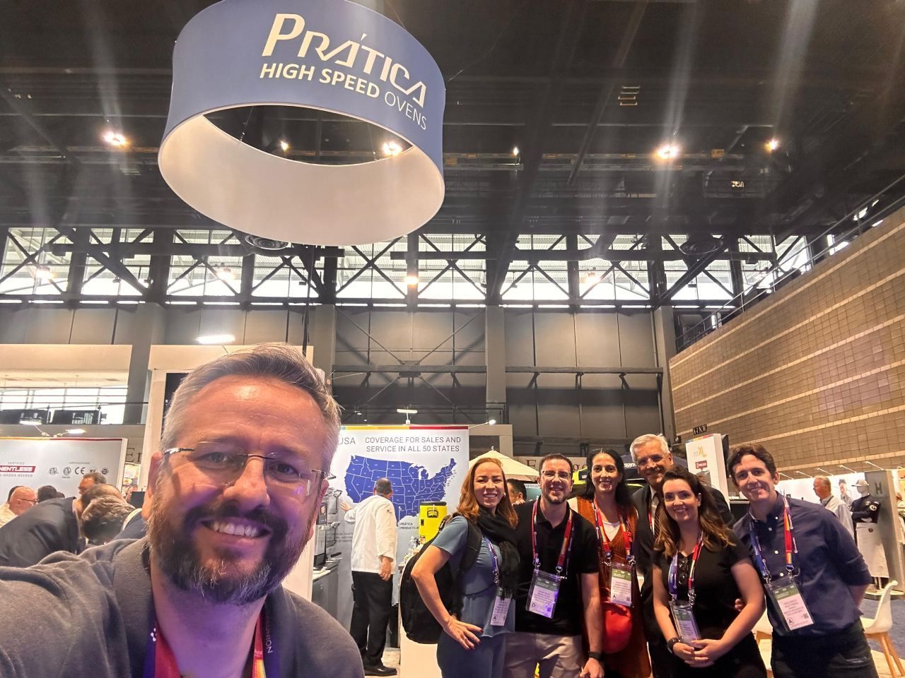 Um grupo de pessoas está posando para uma foto em uma convenção.