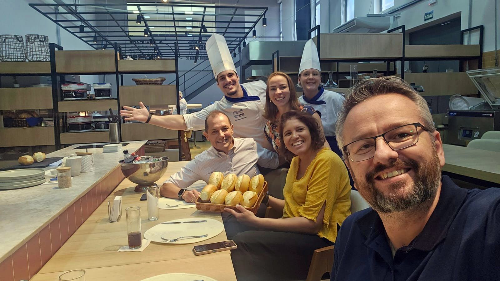 Um grupo de pessoas está posando para uma foto em uma cozinha.