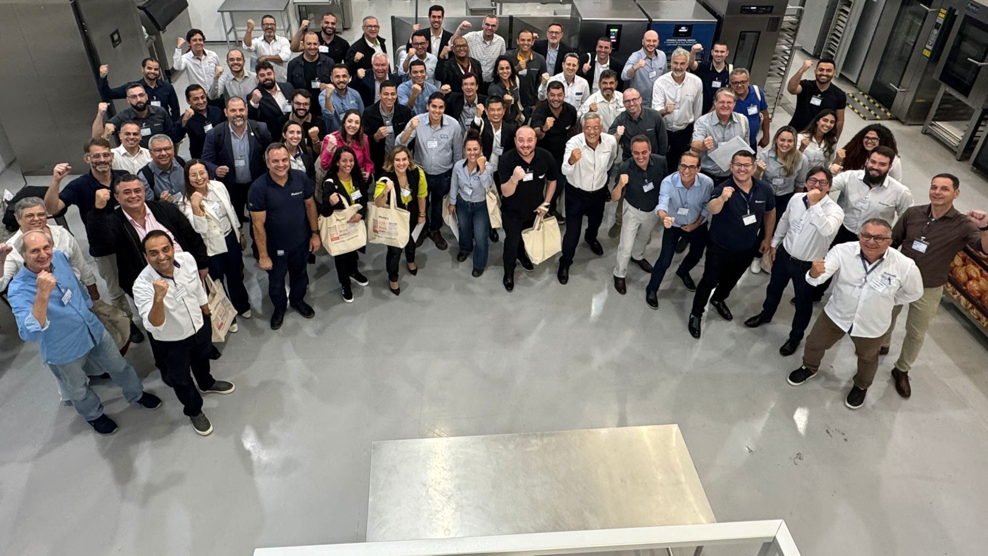 Um grande grupo de pessoas está posando para uma foto em uma sala.