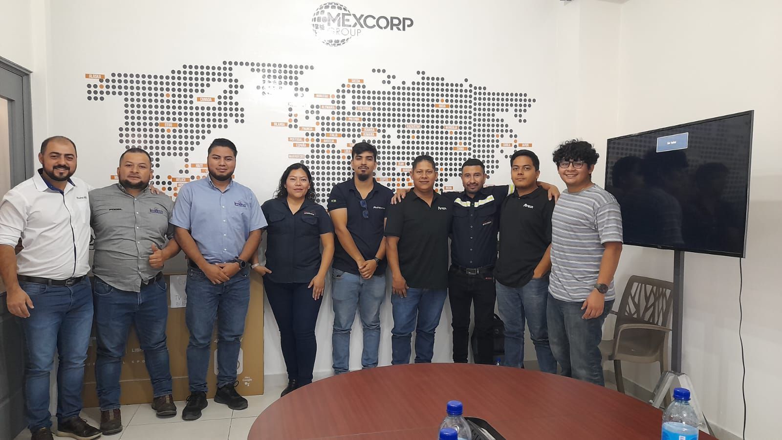 Um grupo de pessoas está posando para uma foto em uma sala.