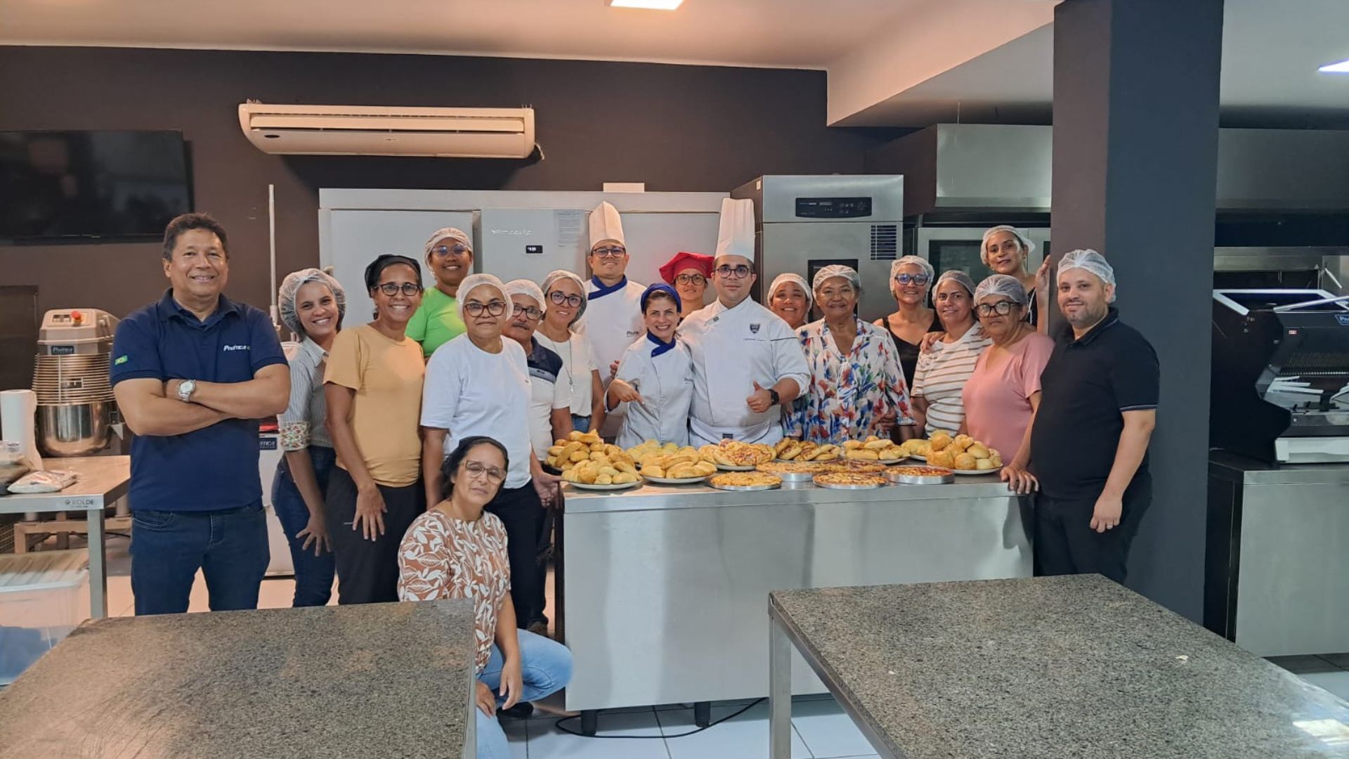Um grupo de pessoas está posando para uma foto em uma cozinha.