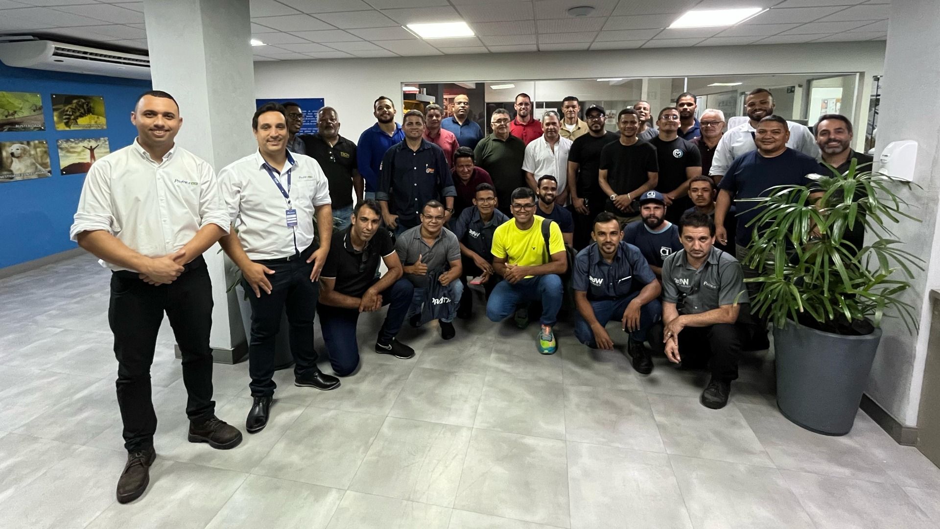Um grupo de homens está posando para uma foto em uma sala.