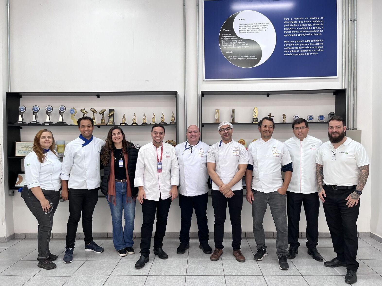 Um grupo de pessoas está posando para uma foto em uma sala.