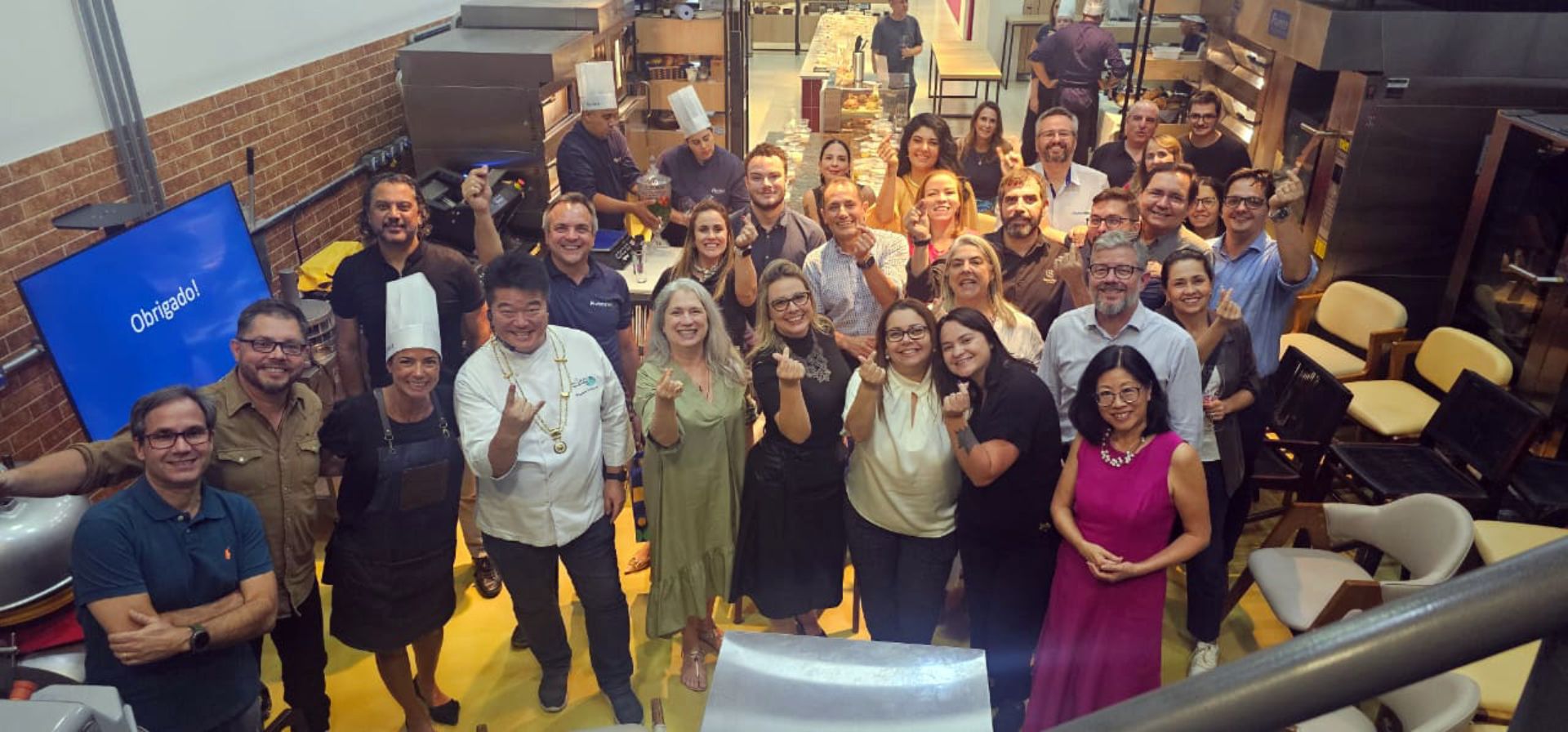 Um grande grupo de pessoas está posando para uma foto em uma sala.