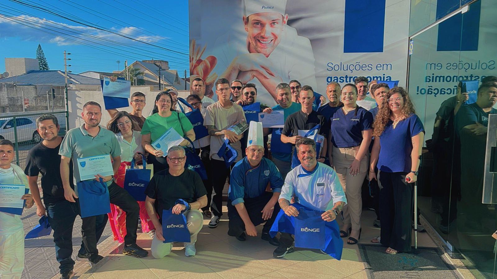 Um grupo de pessoas está posando para uma foto em frente a um caminhão.