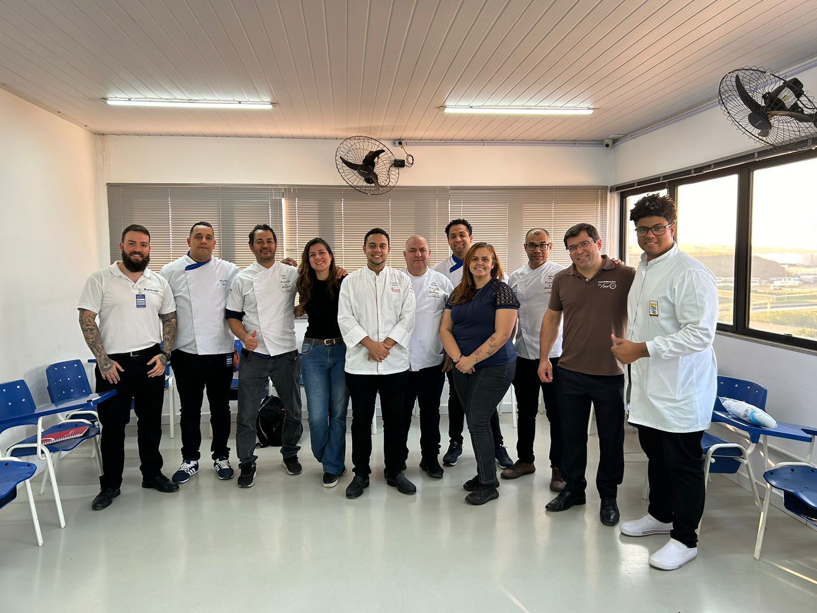 Um grupo de pessoas está posando para uma foto em uma sala.