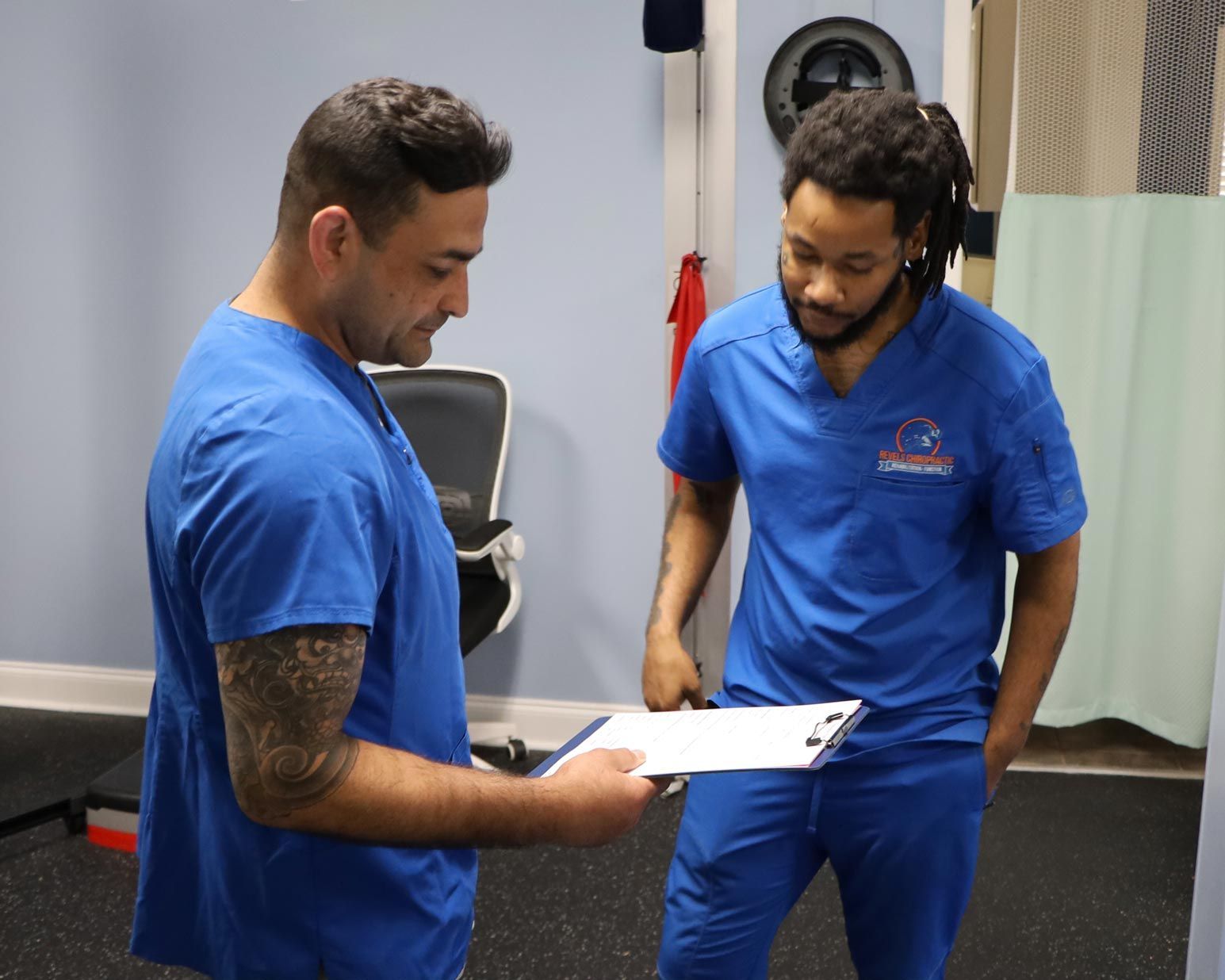 Two people in blue scrubs reviewing a clipboard in a medical setting in Eastover, NC.