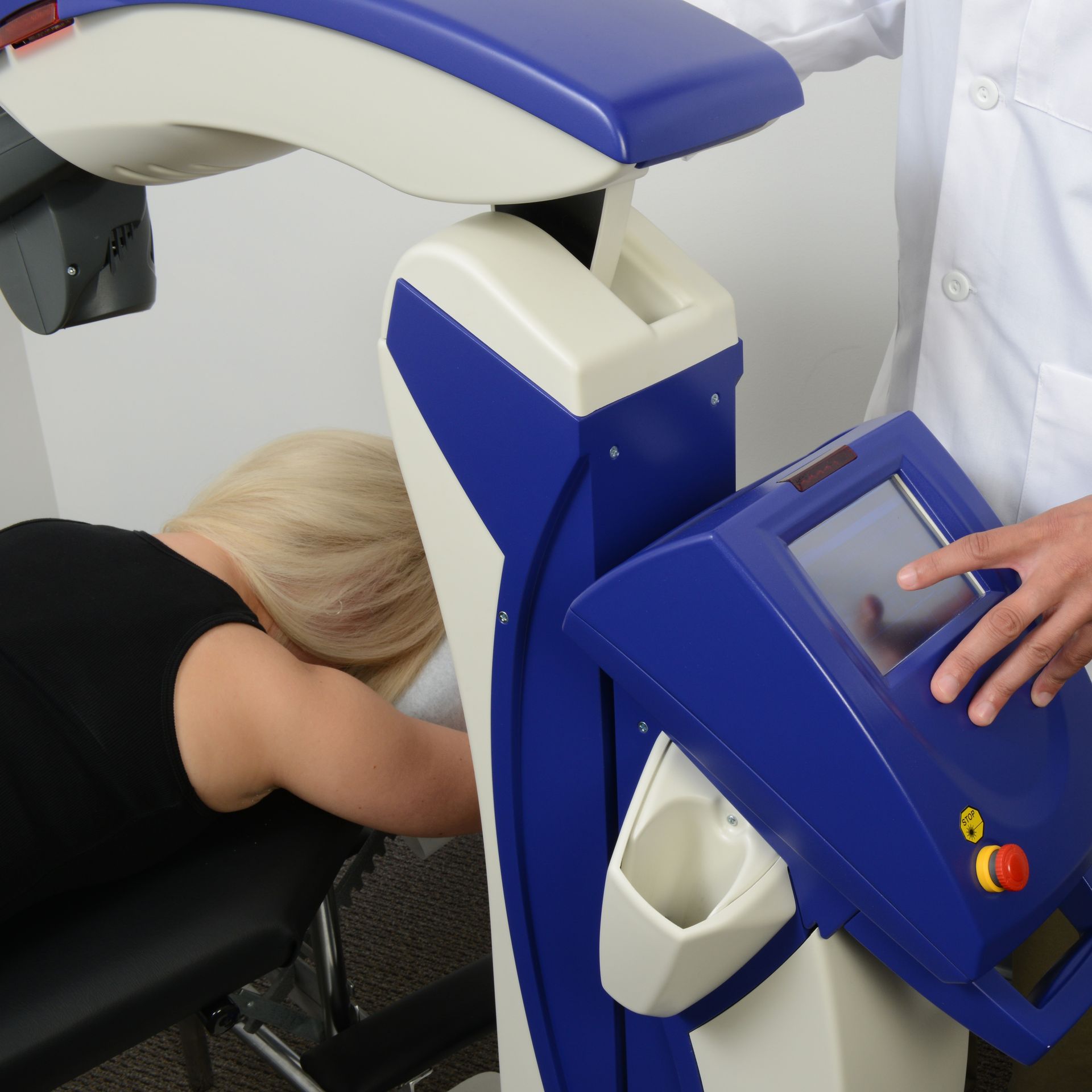 A woman is laying on a blue and white machine