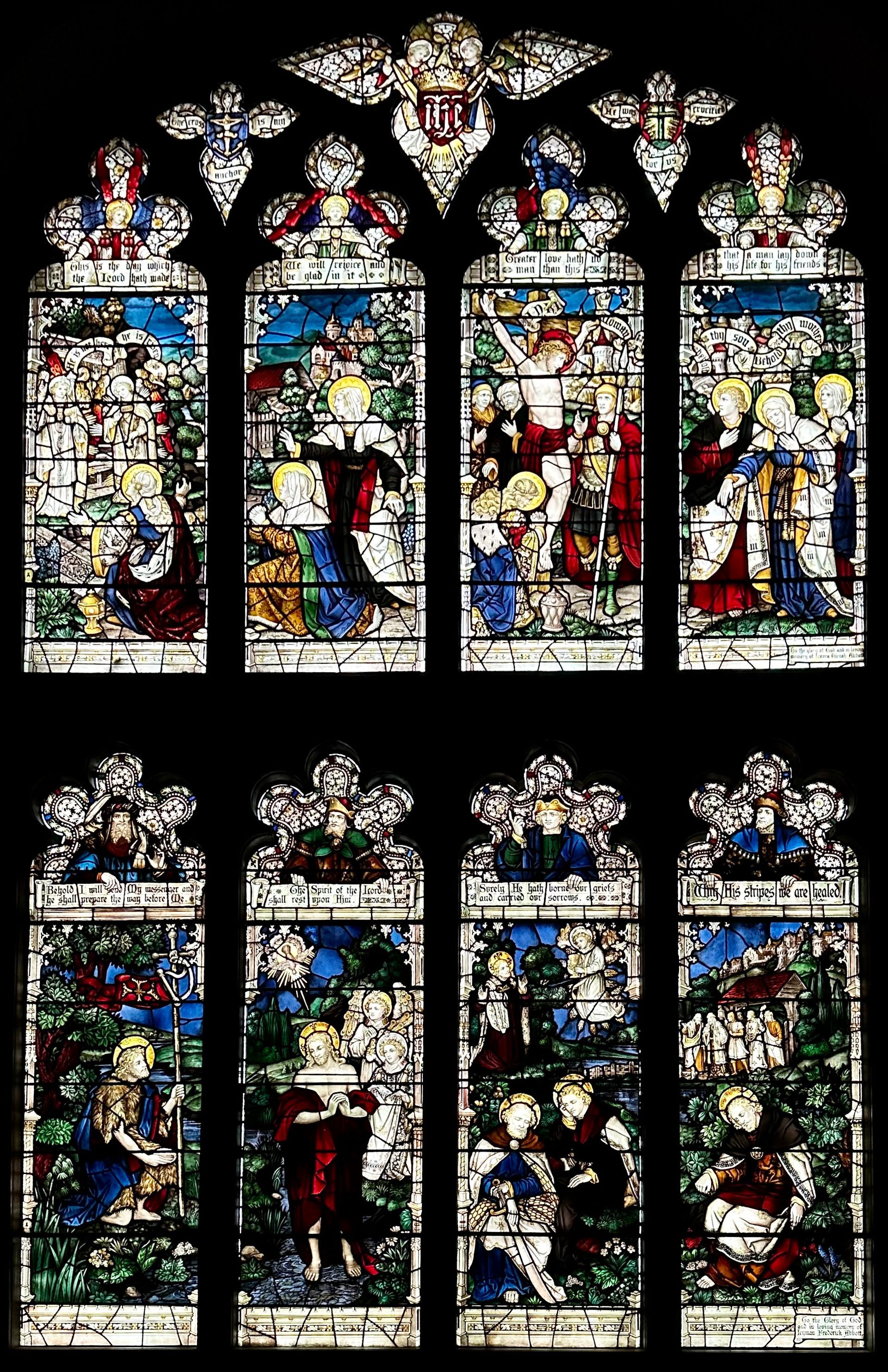 Stained glass window panels depict religious scenes with colorful figures, ornate details, and floral patterns in a church.