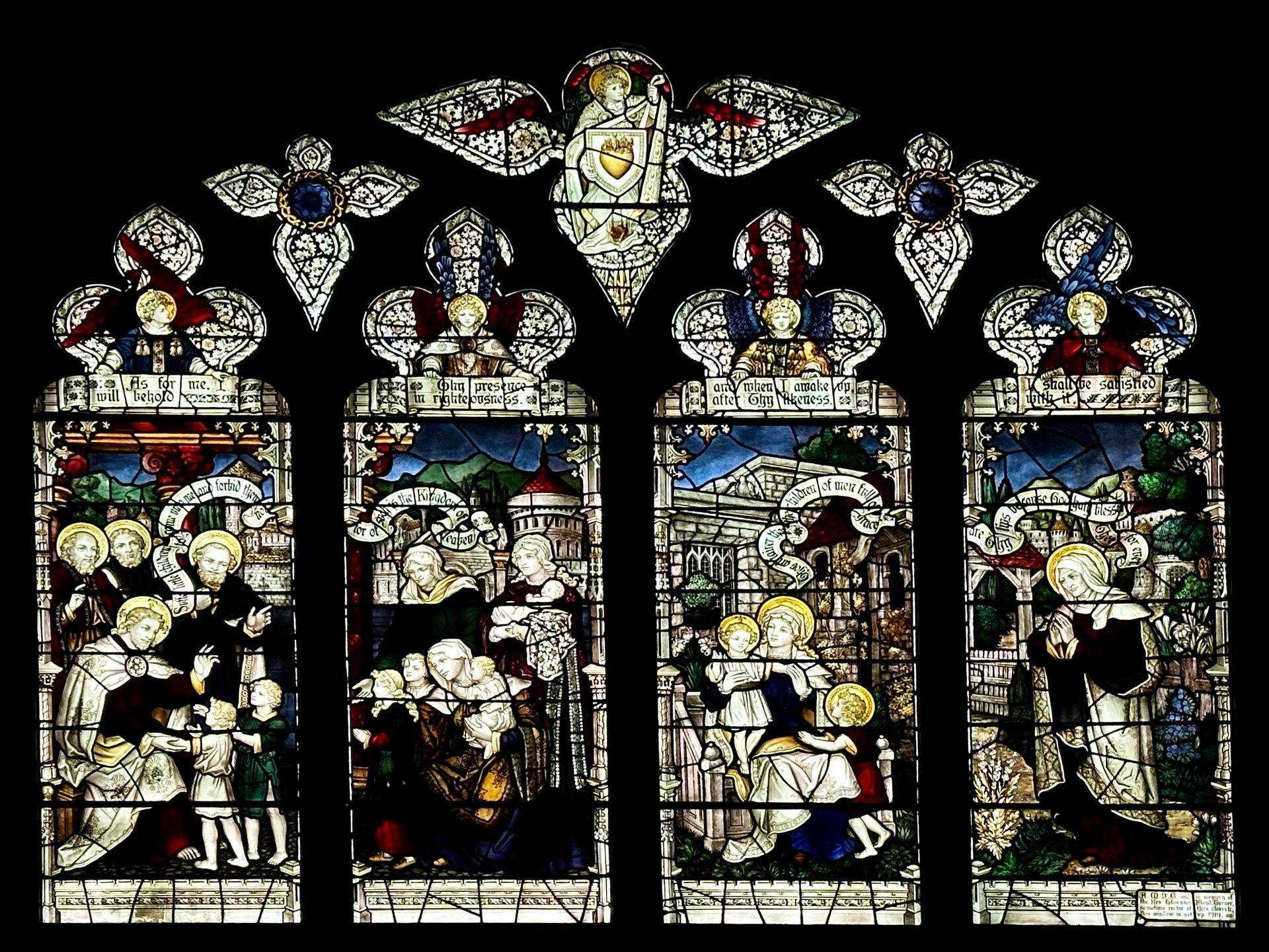 Stained glass window depicting biblical scenes. Figures in colorful clothing and settings, within arched frames.