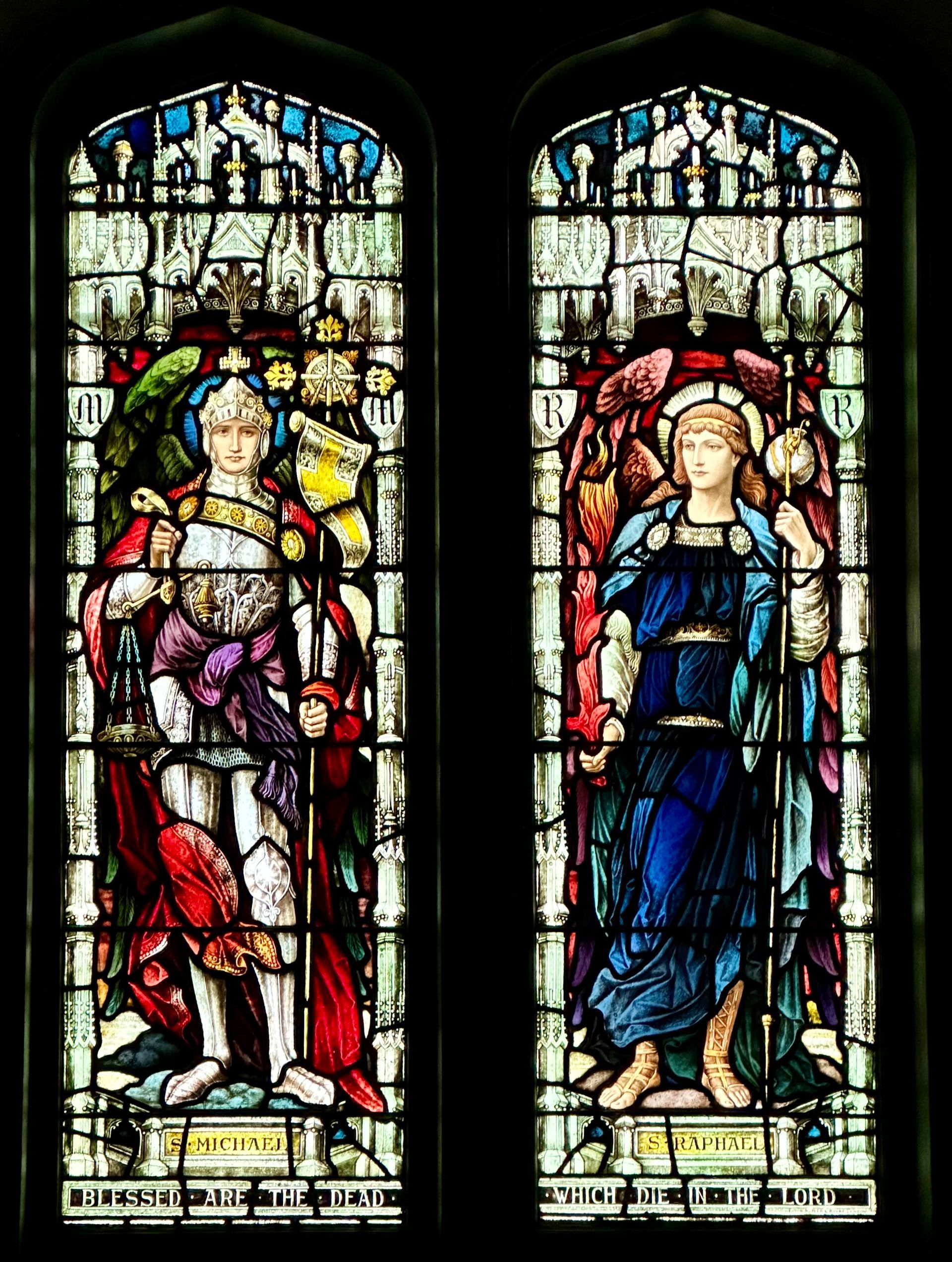 Stained-glass windows: a king and queen. The king wears a crown and holds a staff. The queen wears blue and holds a staff.