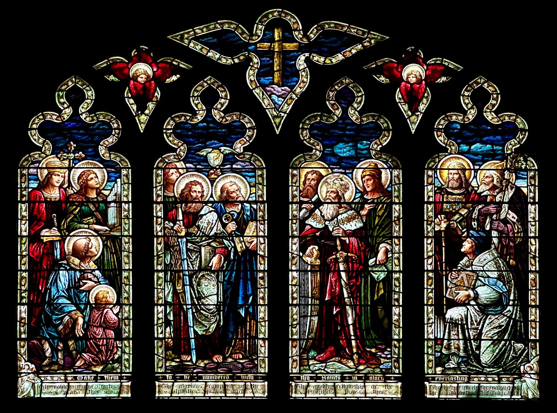 Stained-glass window depicting Jesus and others in biblical scenes, with blue, red, and gold colors.