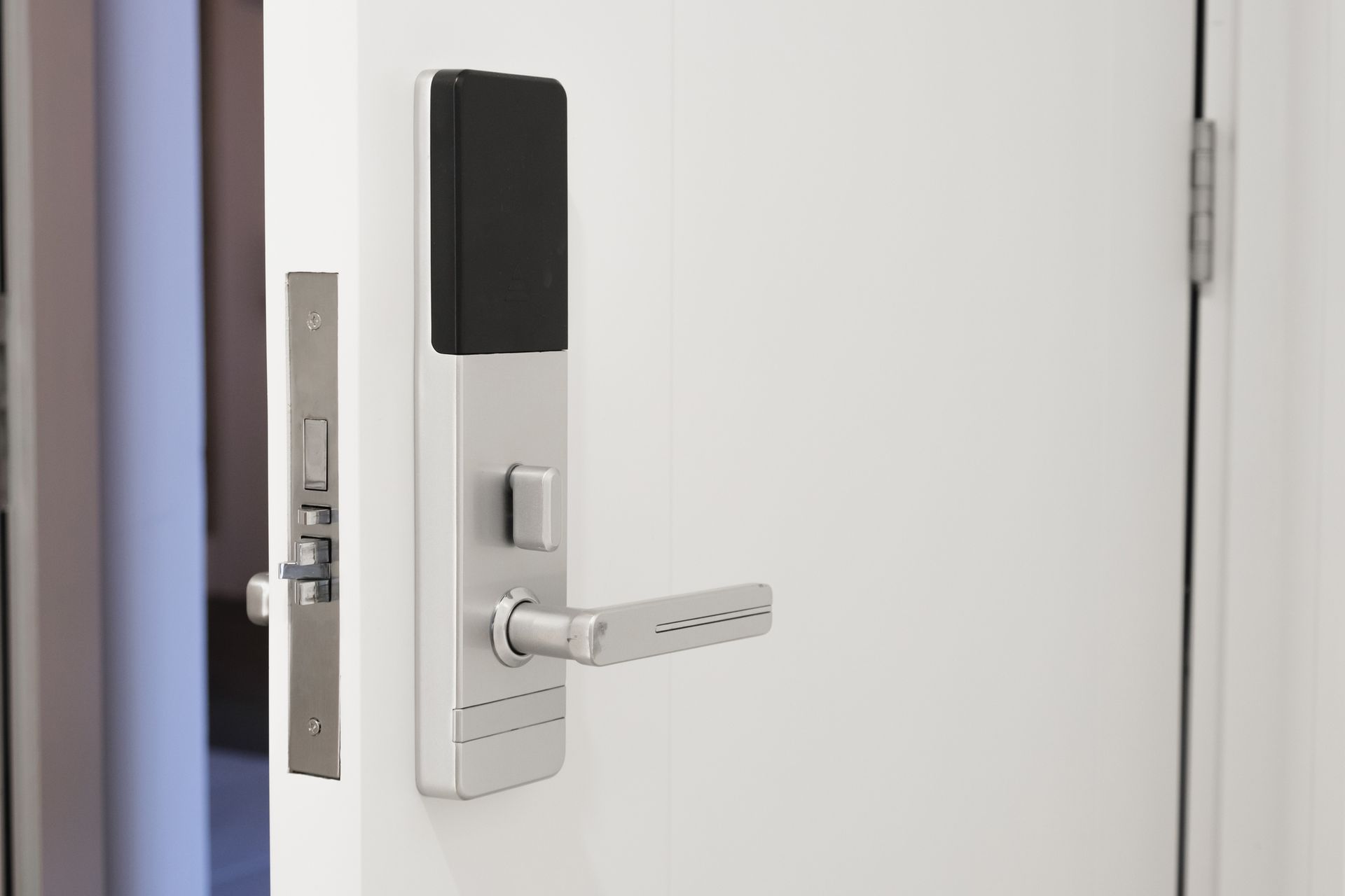 A white door with a digital door lock on it.