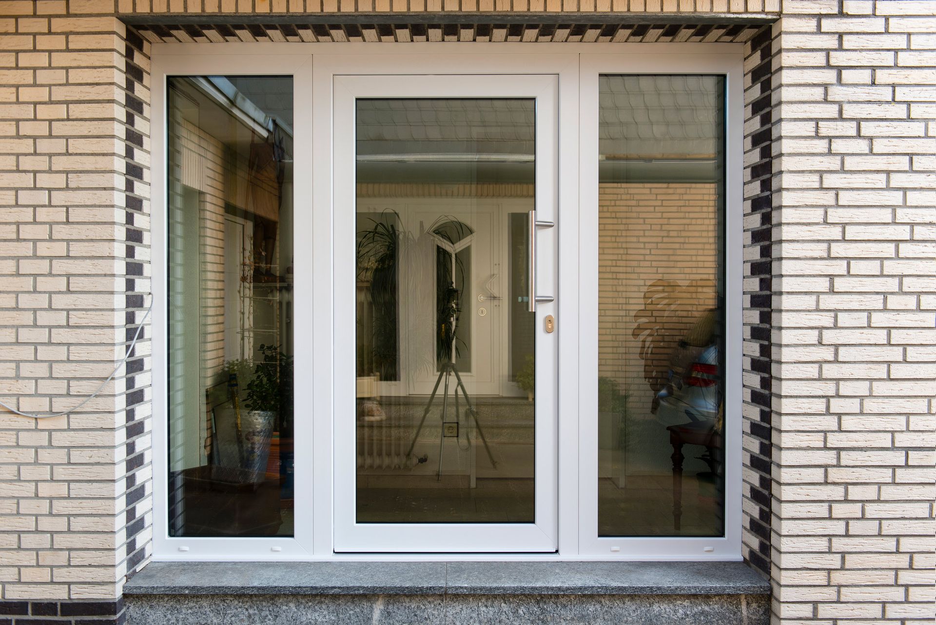 A white door with a lot of glass is on a brick building.