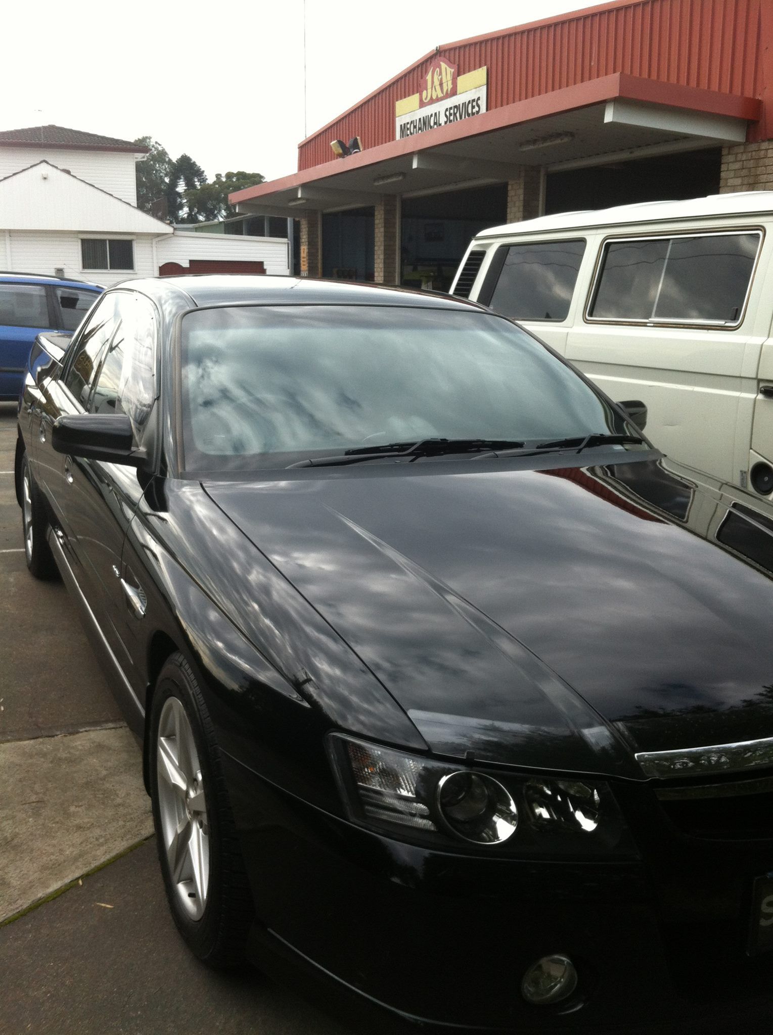 A Black Car is Parked in Front of a Building — J & W Mechanical In Elermore Vale, NSW