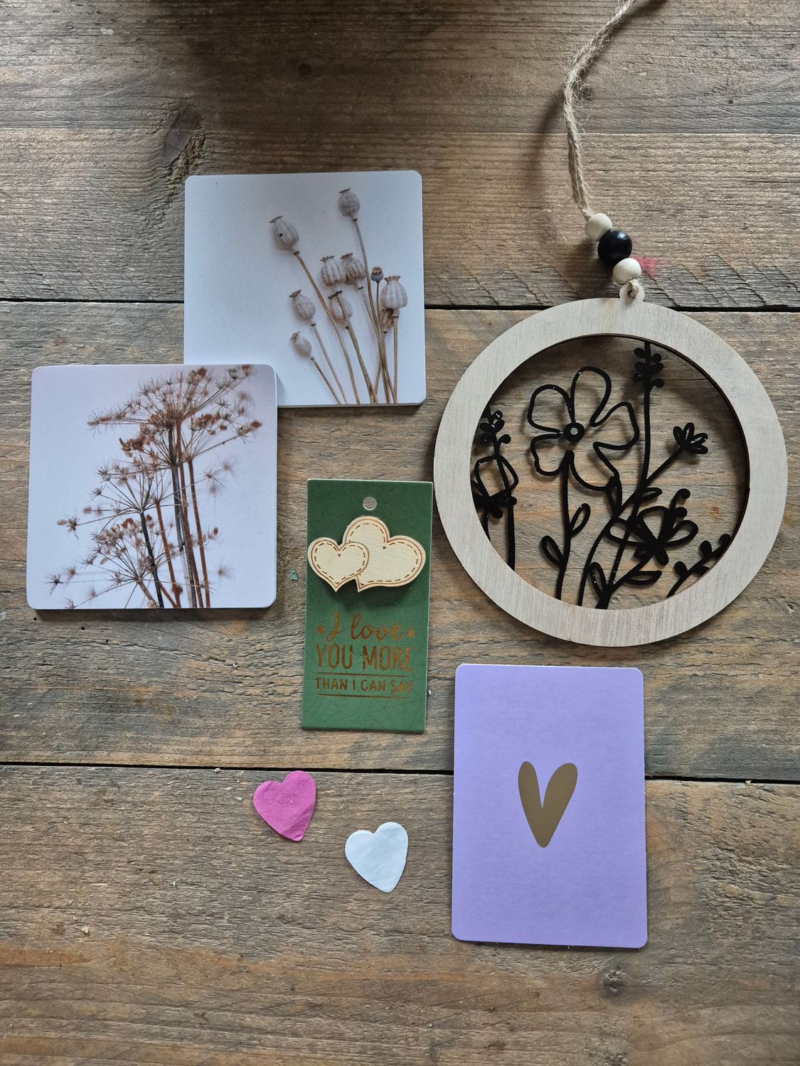 Cadeauverpakking met een bloemenprint, een gouden hartvormig kaartje en een groen kaartje met de tekst