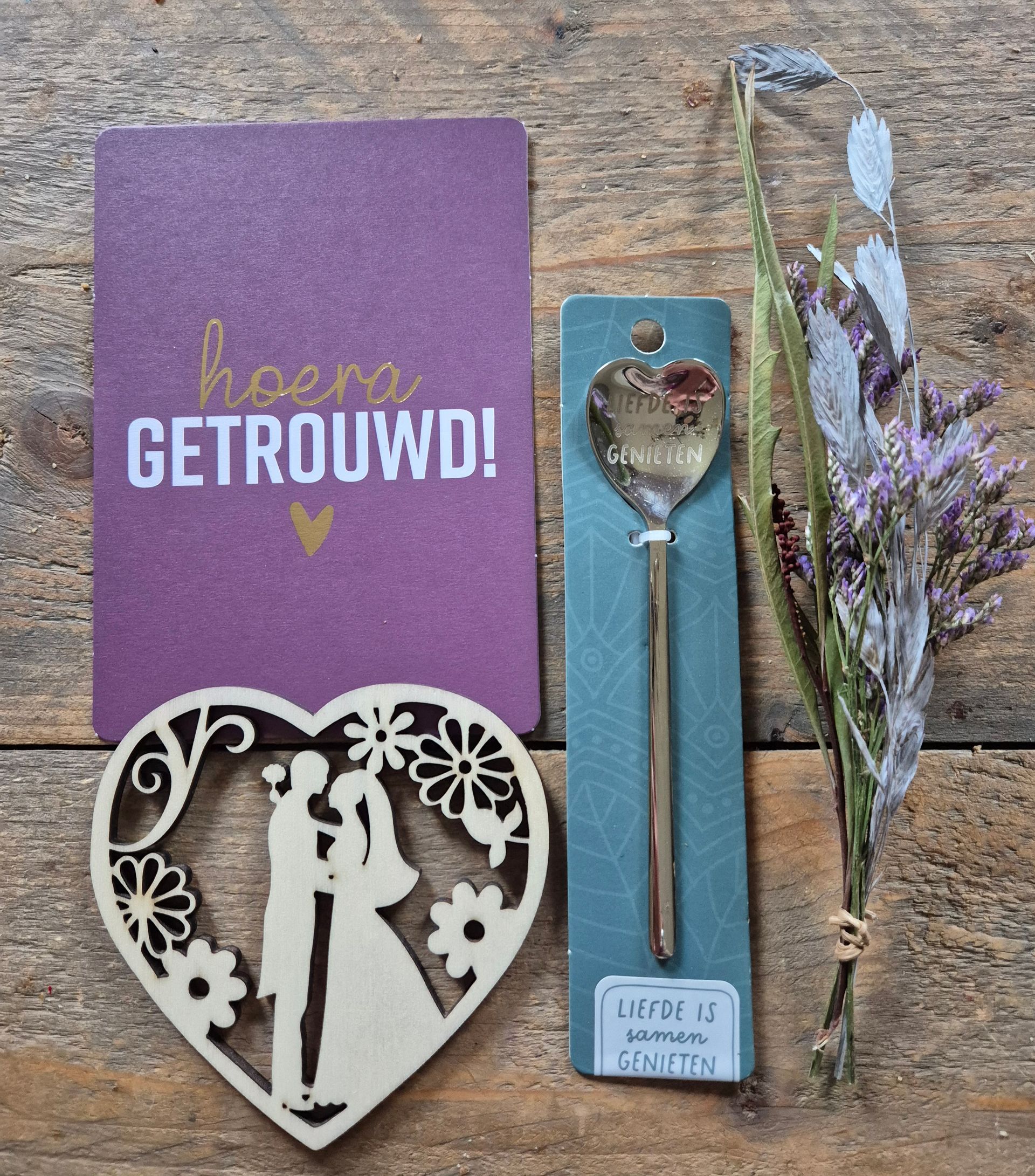 Cadeauverpakking met paarse bloemen, een hartvormig ornament en de tekst