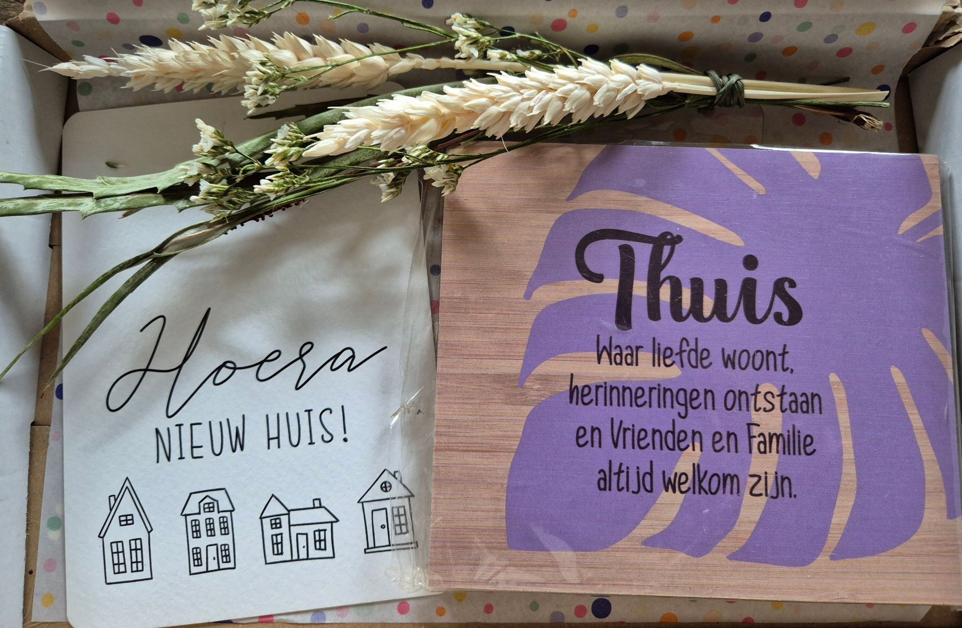 Two folded Dutch cards with flowers: one says “Hoera nieuw huis!”, the other “Thuis is …”