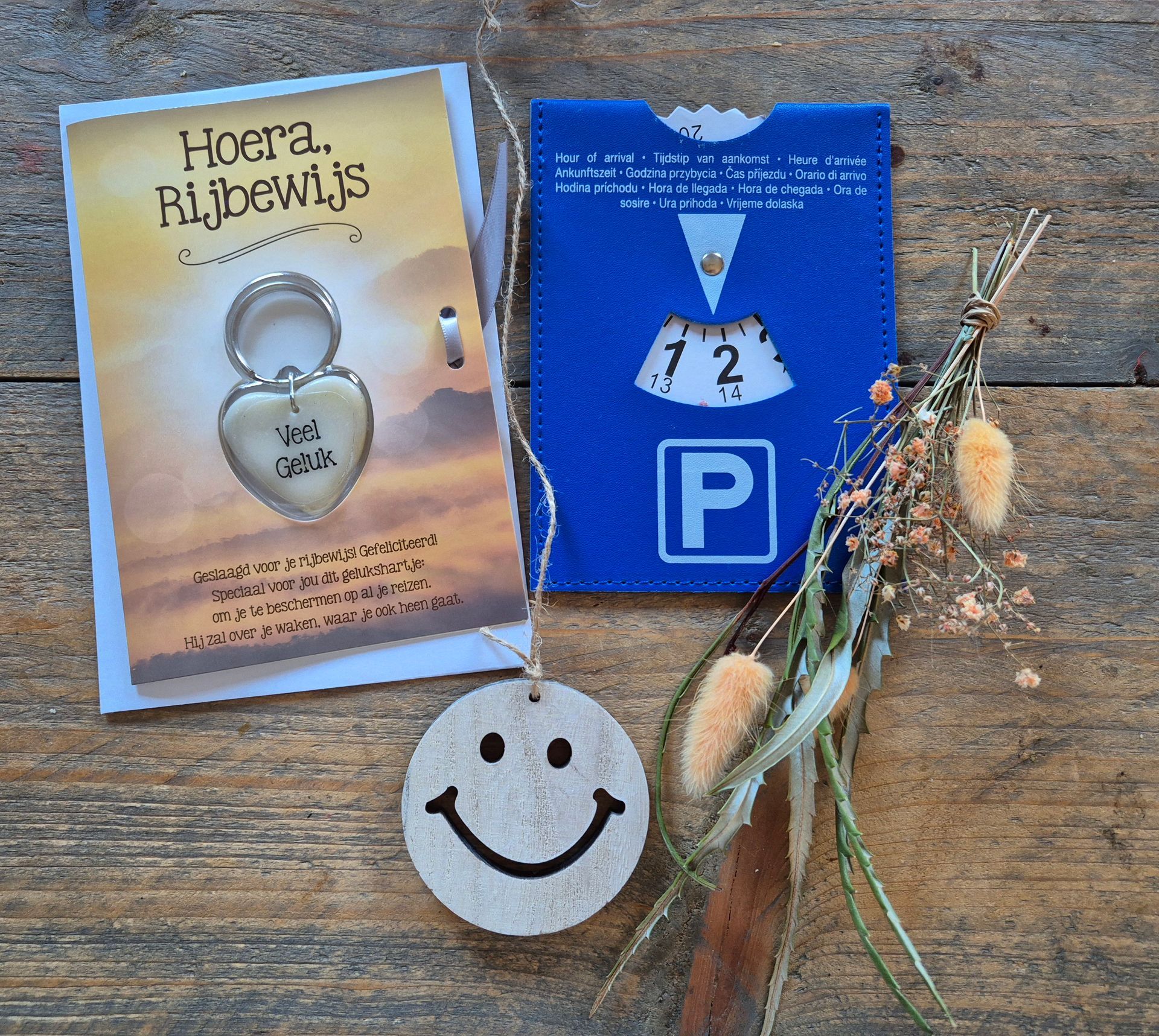 Cadeauset met een hangslot, een blauw kaartje en een label met een smiley op een houten ondergrond.