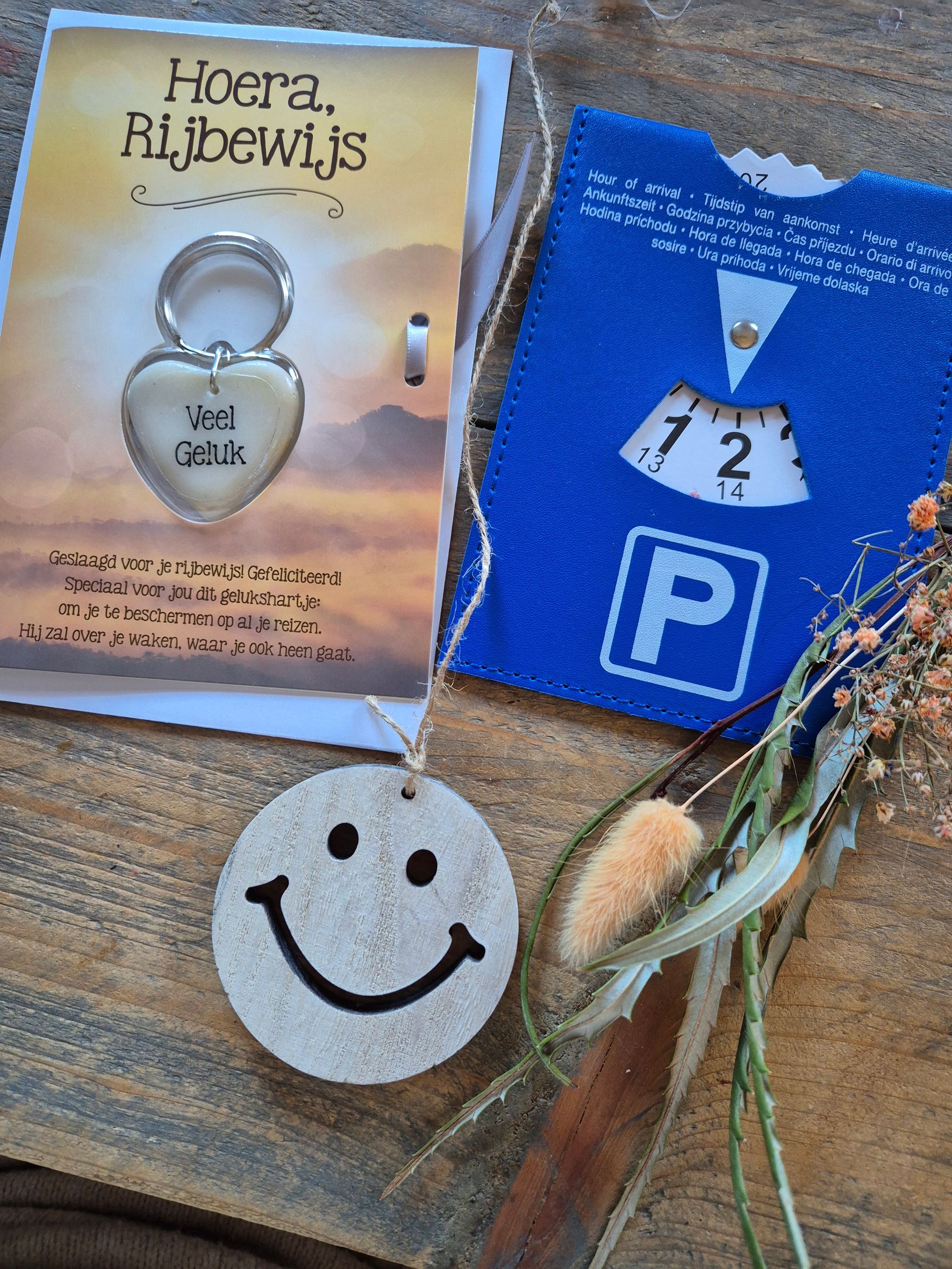 Cadeauset met een hangslot, een blauw kaartje en een label met een smiley op een houten ondergrond.