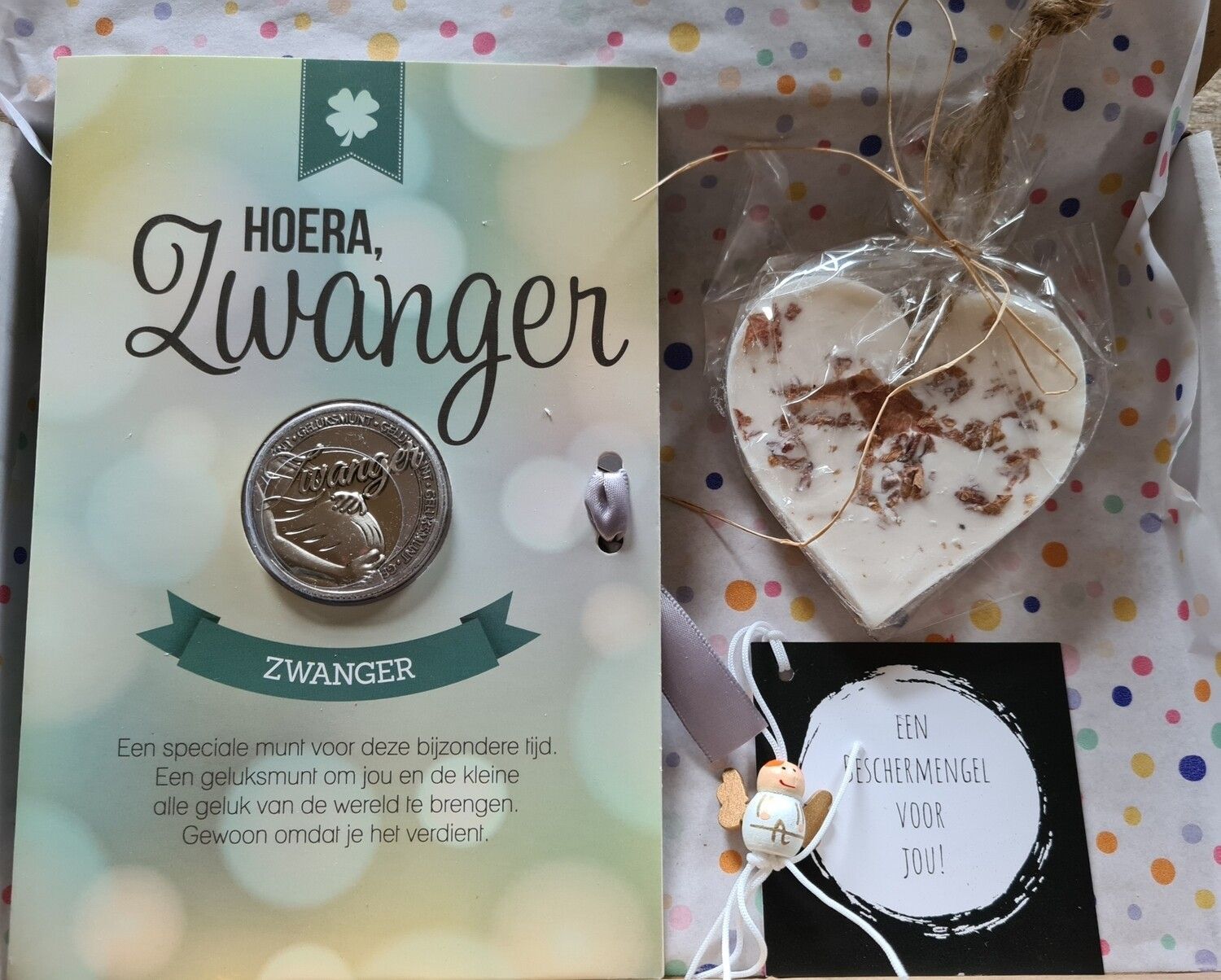 Nederlandse zwangerschapsaankondigingskaart met een munt, een hartje en een klein cadeaulabel op een achtergrond met stippen.