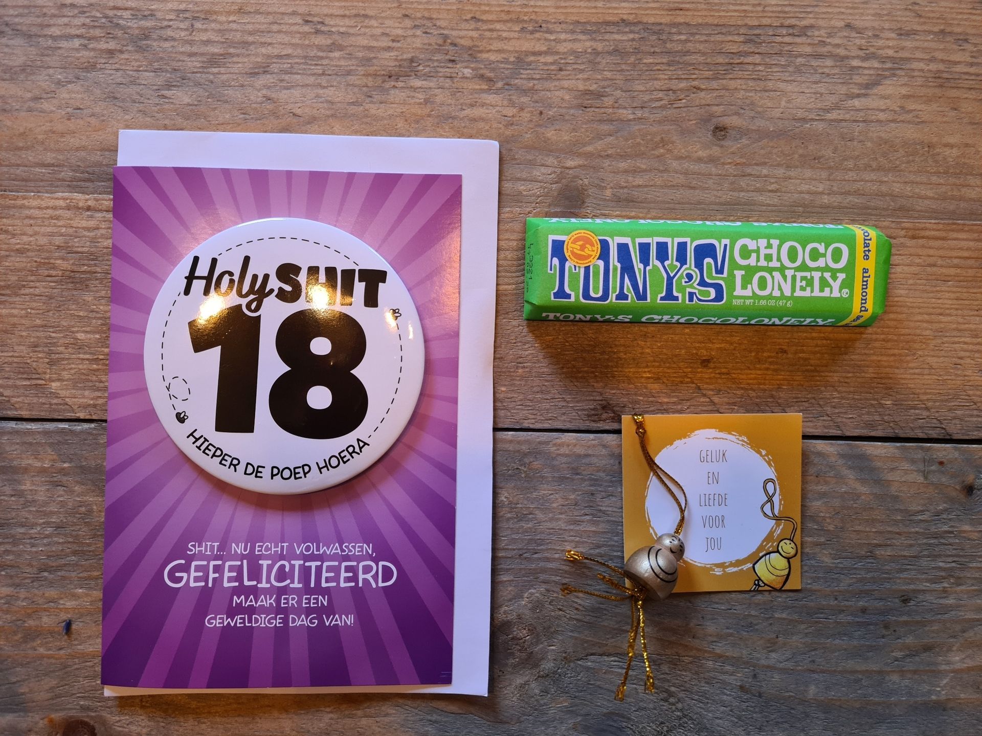 Een verjaardagscadeaubox met kaartjes en lekkernijen, waaronder een kaartje met de tekst