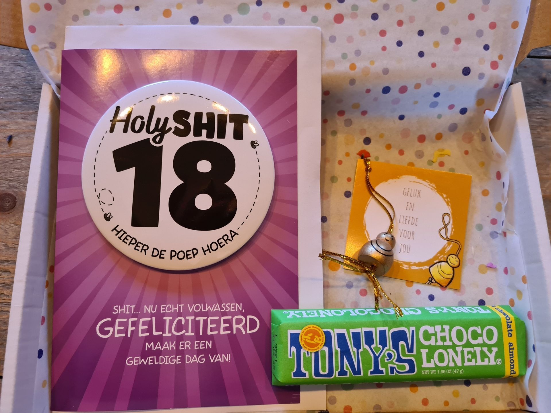 Een verjaardagscadeaubox met kaartjes en lekkernijen, waaronder een kaartje met de tekst