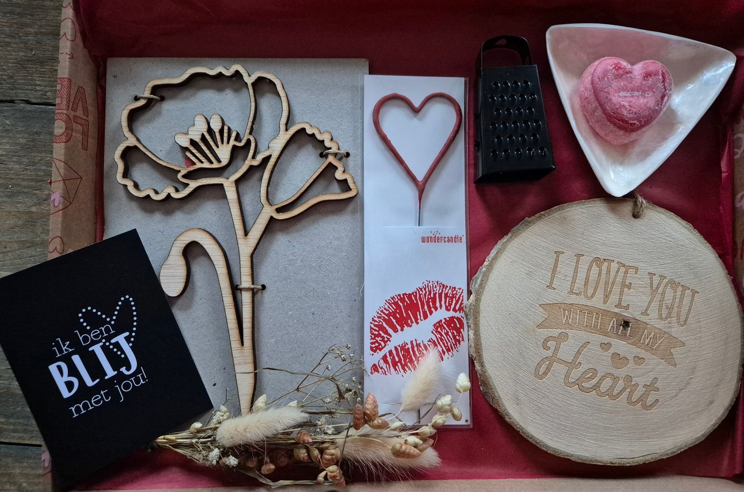 Een tafel vol Valentijnsdagcadeaus met hartvormige decoraties, kaarten, een onderzetter, chocolaatjes en rode accenten.