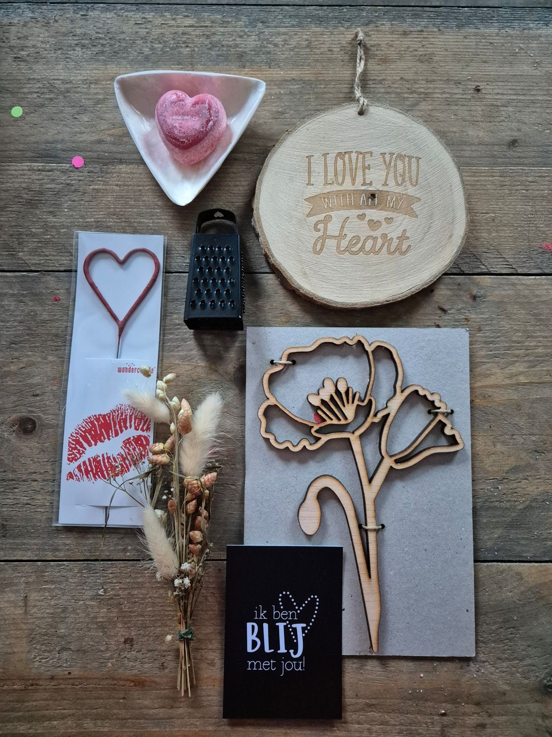 Een tafel vol Valentijnsdagcadeaus met hartvormige decoraties, kaarten, een onderzetter, chocolaatjes en rode accenten.