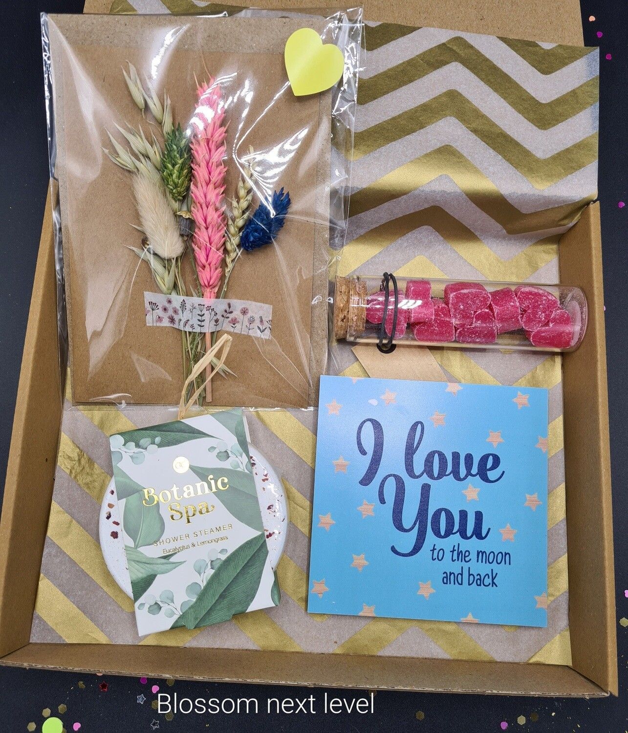 Cadeauverpakking met veren, roze glitterclip, hartballon en