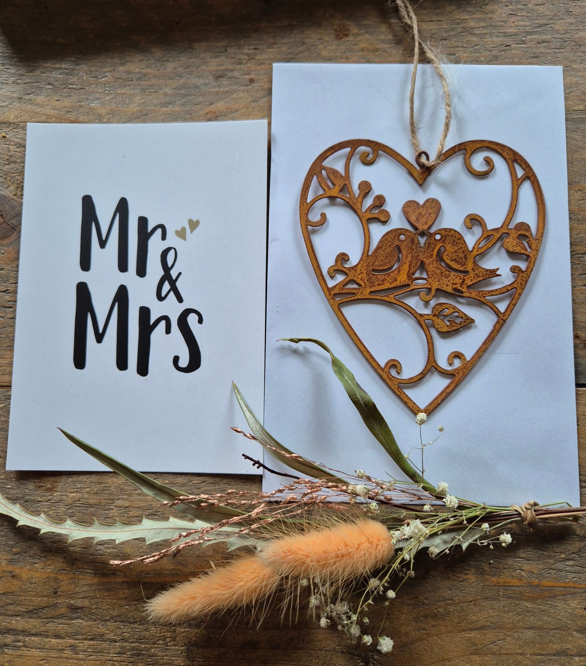Kaartjes voor meneer en mevrouw, één met zwarte tekst en één met een gouden hartje en touwtje.