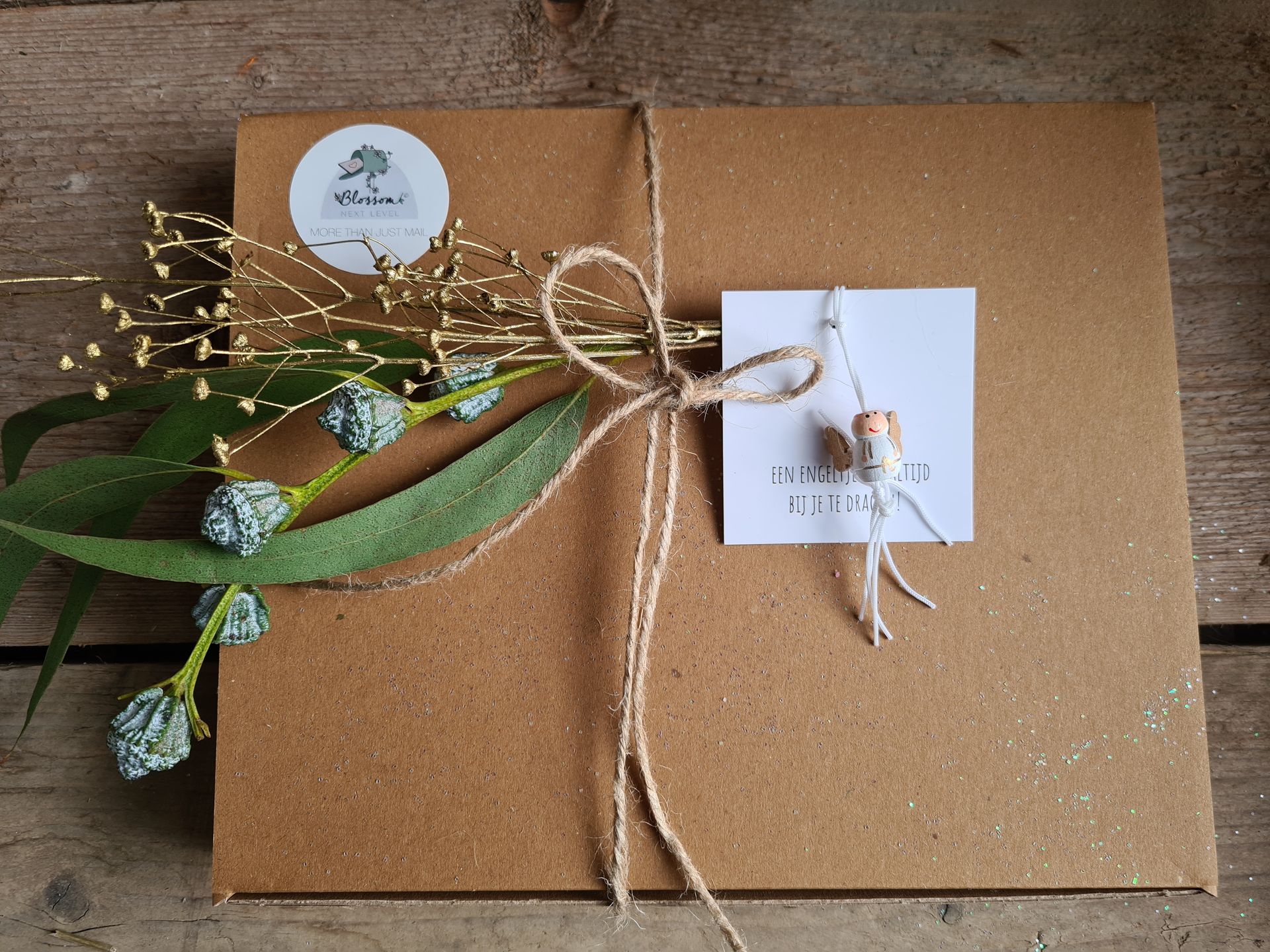 Bruine geschenkdoos, ingepakt met touw, groen en een klein wit labeltje.