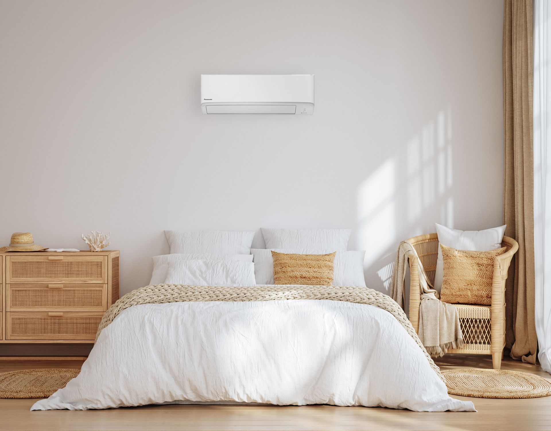 Bedroom with white bedding, air conditioner, wooden furniture, and woven chair.
