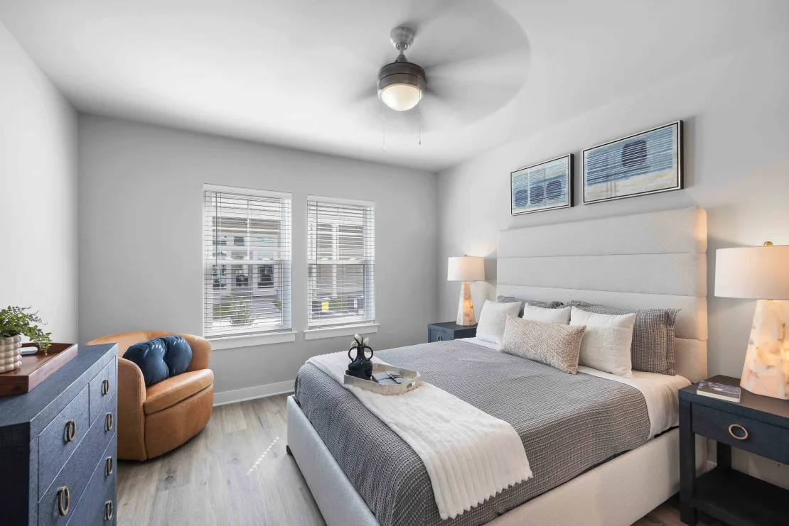 Bright modern bedroom with a queen bed, two nightstands, and a dresser.