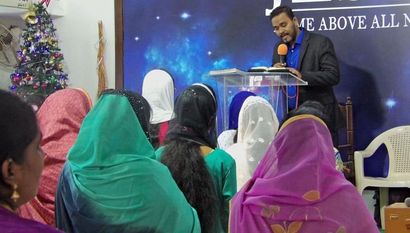 A man is standing at a podium giving a speech to a group of people.